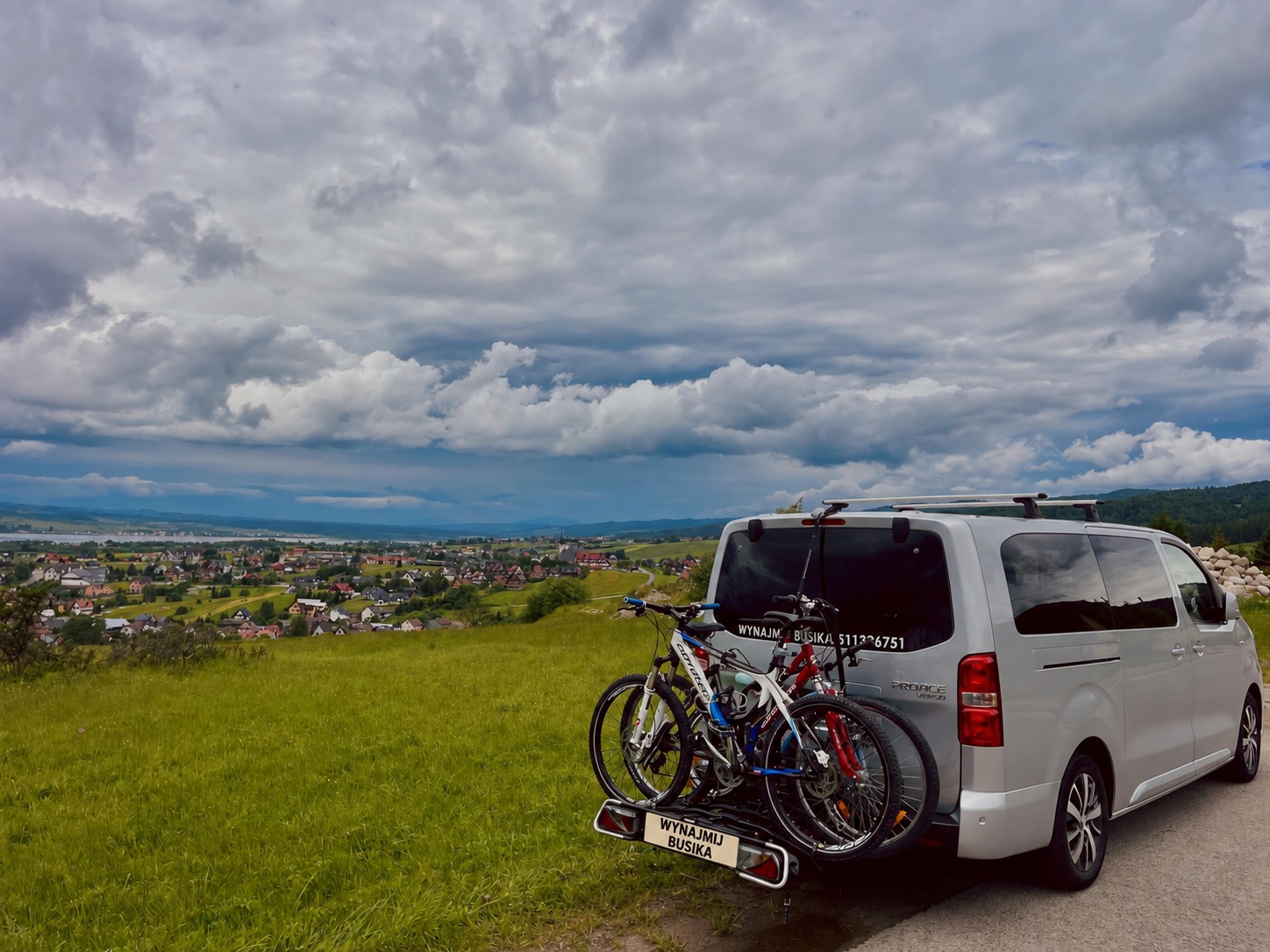 Toyota z rowerami na bagażniku, na tle górskiej panoramy